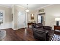 Inviting foyer with dark wood floors, decorative wainscoting, and a charming chandelier create a warm welcome at 8909 N Campbell Rd, Lakeland, FL 33810