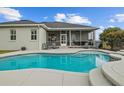 Inviting in-ground pool with screened-in lanai and outdoor seating area for relaxation at 8909 N Campbell Rd, Lakeland, FL 33810