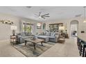 Spacious living room featuring neutral tones, a ceiling fan, and sliding glass doors to the backyard at 1001 Lena Run Ct, Winter Haven, FL 33880