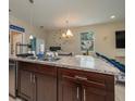 Open-concept kitchen with a breakfast bar, stainless steel sink, and view of the dining area at 1105 Watersedge Dr, Lakeland, FL 33801