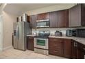 Modern kitchen featuring stainless steel appliances, stylish dark wood cabinetry, and ample countertop space at 1105 Watersedge Dr, Lakeland, FL 33801