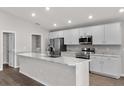 Bright kitchen features white cabinets, stainless steel appliances, a large island, and modern finishes at 1106 Tropea Ln, Auburndale, FL 33823