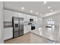 Well-lit kitchen with white cabinetry, stainless steel appliances, granite countertops, and an island at 1106 Tropea Ln, Auburndale, FL 33823