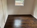An empty room showcasing wood flooring and a single window providing natural light at 1160 Austin St, Bartow, FL 33830