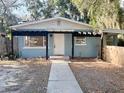 Charming single-story home featuring a black pergola and inviting front entrance in a tree-filled yard at 1160 Austin St, Bartow, FL 33830