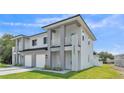 Modern two-story home featuring a light gray exterior, white accents, and a well-maintained lawn at 1171 Windjammer Dr, Lakeland, FL 33803