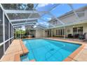 View of the screened-in pool and deck with access to the home via French doors at 1218 Lake Point Ter, Lakeland, FL 33813