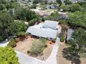 Aerial view showcases a home with a pool, mature trees, and a long driveway leading to the residence at 16 Golfview Ne Cir, Winter Haven, FL 33881