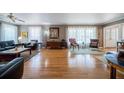 Comfortable living room with hardwood floors, sheer curtains, and ample natural light through expansive windows at 16 Golfview Ne Cir, Winter Haven, FL 33881