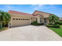 Attractive home exterior with a two-car garage, tile roof, and neatly trimmed landscaping at 1772 Laurel Glen Pl, Lakeland, FL 33803