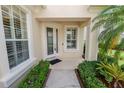 Inviting front porch featuring a glass door, manicured bushes, and a palm tree at 1772 Laurel Glen Pl, Lakeland, FL 33803