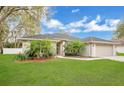 Lovely home with lush green lawn, beautiful trees, and an attached two-car garage at 1837 Farrington Dr, Lakeland, FL 33809