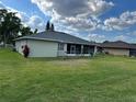 Expansive backyard with green lawn, featuring a screened in lanai at 200 S Goodman Ave, Lake Alfred, FL 33850