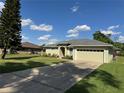 Well-manicured home exterior featuring a lovely green lawn and a long driveway at 200 S Goodman Ave, Lake Alfred, FL 33850