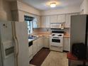 Functional kitchen featuring essential appliances and ample cabinet storage space at 220 Pinehurst Dr, Auburndale, FL 33823