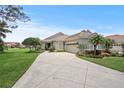 Well-maintained home with green lawn, mature trees, and a side garage at 2569 Laurel Glen Dr, Lakeland, FL 33803