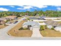 Aerial view of a well-maintained home with lush landscaping in a quiet residential neighborhood, featuring a grey roof at 2700 Oak Hammock Loop, Mulberry, FL 33860