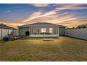 Spacious backyard features a screened-in porch, white fence, outdoor seating, grill and fire pit, perfect for entertaining at 2700 Oak Hammock Loop, Mulberry, FL 33860