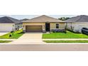 Single-story home featuring a well-manicured lawn, a two-car garage, and clean, modern landscaping at 297 Spirit Landings Cir, Winter Haven, FL 33880