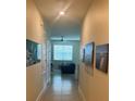 Bright hallway with decorative art leading to a living space with a fan and window at 297 Spirit Landings Cir, Winter Haven, FL 33880