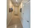 Inviting hallway featuring tile flooring, neutral walls, and white doors with hardware at 297 Spirit Landings Cir, Winter Haven, FL 33880
