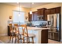 Modern kitchen with stainless steel appliances, granite counters, and breakfast bar seating at 297 Spirit Landings Cir, Winter Haven, FL 33880