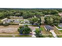 Aerial view of a home and property in a neighborhood surrounded by lush greenery at 305 Woods Landing Dr, Lady Lake, FL 32159