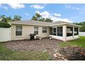 The backyard features a BBQ, a small eating area and a screened-in lanai at 305 Woods Landing Dr, Lady Lake, FL 32159