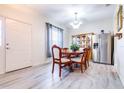 Bright dining room with new light gray floors, stainless steel refrigerator and wooden dining set at 3281 Enclave Blvd, Mulberry, FL 33860