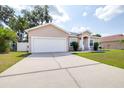 Charming single-story home with a well-lit driveway and an attached two car garage at 3281 Enclave Blvd, Mulberry, FL 33860