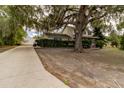 Two-story home with covered porch and a long driveway leading to a garage and vehicle at 330 W Palmetto St, Lakeland, FL 33815