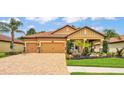 Inviting home featuring manicured landscaping, a paver driveway, and a warm, neutral color palette at 3926 Aquilla Dr, Lakeland, FL 33810