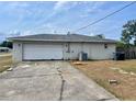 Rear view showing a two-car garage and long concrete driveway on a sunny day at 4038 Lehman Ln, Lakeland, FL 33813