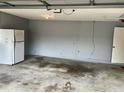 Interior shot of the garage, showing a concrete floor and a white refrigerator at 4038 Lehman Ln, Lakeland, FL 33813