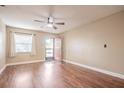 Spacious living room with hardwood floors, a ceiling fan, and a bright window at 526 Marklen Loop, Polk City, FL 33868