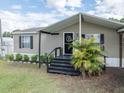 Inviting entrance with well-maintained landscaping and a welcoming black front door at 5339 Meadow Grove Trl, Lakeland, FL 33810