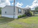 Exterior view of a cozy home, displaying the side yard and carport at 5339 Meadow Grove Trl, Lakeland, FL 33810