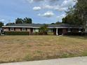 Inviting single-story brick home featuring mature landscaping and a well-manicured lawn at 5604 Stratford Ln, Lakeland, FL 33813