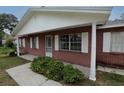 Charming brick home featuring a cozy front porch, white accents, and well-maintained landscaping at 6131 Doe E Cir, Lakeland, FL 33809