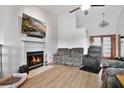 Cozy living room featuring a fireplace, vaulted ceilings, and wood flooring at 6750 Lemon Tree Dr, Lakeland, FL 33813