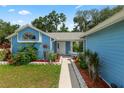 Inviting front entrance, with a walkway surrounded by garden beds filled with colorful flowers and green plants at 6810 Palomino Dr, Lakeland, FL 33811