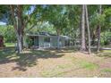 Inviting single-Gathering home nestled amongst mature trees, featuring a carport and well-manicured front lawn at 921 Avon Ave, Lakeland, FL 33801