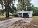 Charming single-story home with garage, gray brick, front shrubbery, and large front driveway at 930 E Tee Cir, Bartow, FL 33830