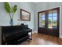 Bright foyer showcasing a piano, wood floors, and an entryway with double doors that opens to the front yard at 1 Brogden Se Ct, Winter Haven, FL 33880