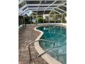 Inviting screened-in pool featuring a brick paver deck and clear, blue water at 1110 Cypress W Pt, Winter Haven, FL 33884