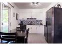 Modern kitchen featuring sleek white cabinets, stainless steel appliances, and sliding glass doors at 1160 Eleanore Ave, Bartow, FL 33830
