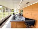 Screened in patio with tiled floor, jacuzzi and an outdoor TV for entertaining at 1208 W Lake Buckeye Dr, Winter Haven, FL 33881