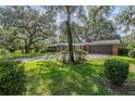 Lovely brick house with an attached garage surrounded by lush greenery at 1317 Old Polk City Rd, Lakeland, FL 33809
