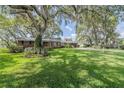 Classic brick home with lush lawn and mature trees providing shade at 1317 Old Polk City Rd, Lakeland, FL 33809