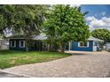 Beautiful blue single-story home with brick driveway and mature trees at 1328 Edgewater Beach Dr, Lakeland, FL 33805